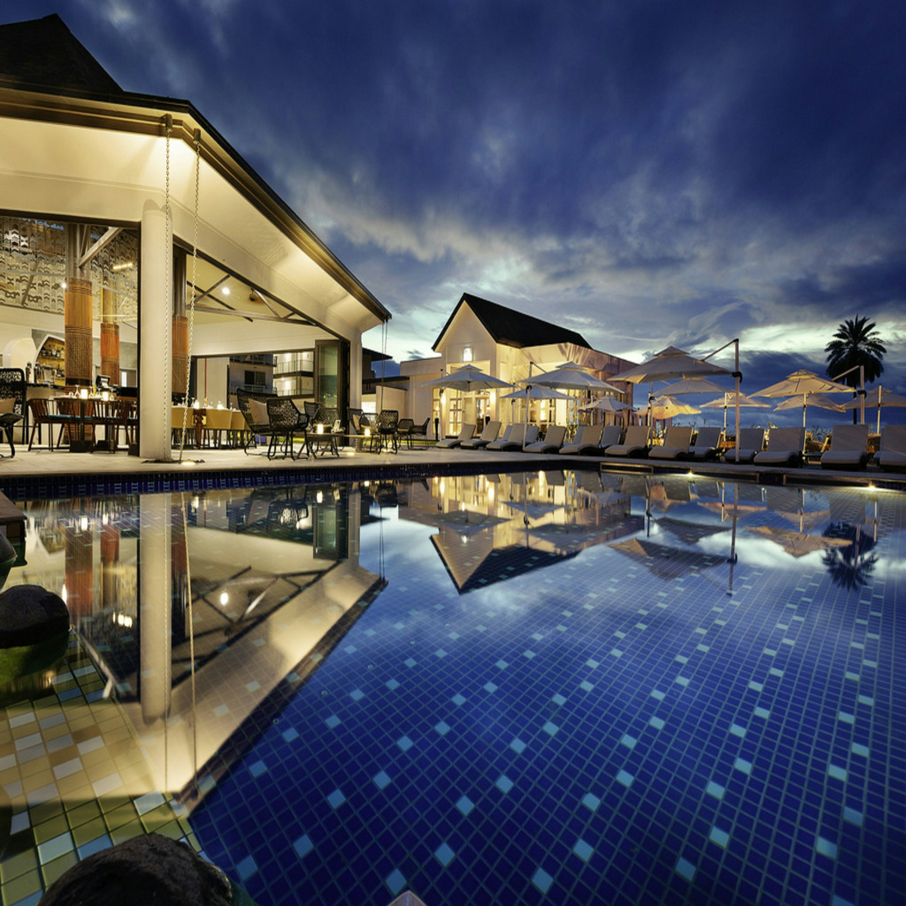 Resort hospitality setting with an illuminated terrace and pool